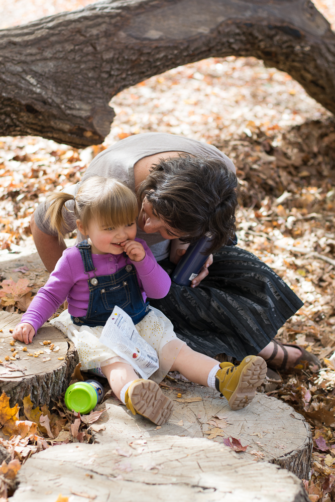A toddler having a snack with her mother at Ijams Nature Center.