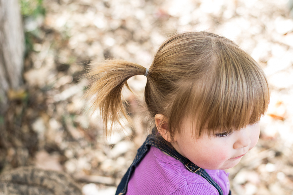 A little girl with pigtails stares off into space.