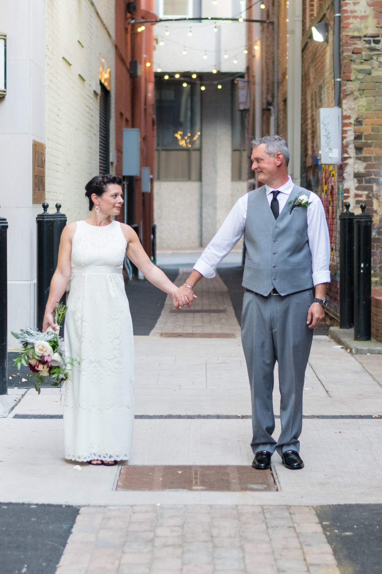 Bride and groom stand in Strong Alley behind Market Square.
