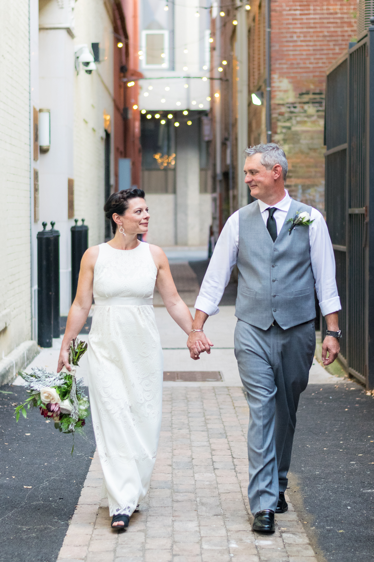 Bride and groom walk down Strong Alley after their Market Square wedding.