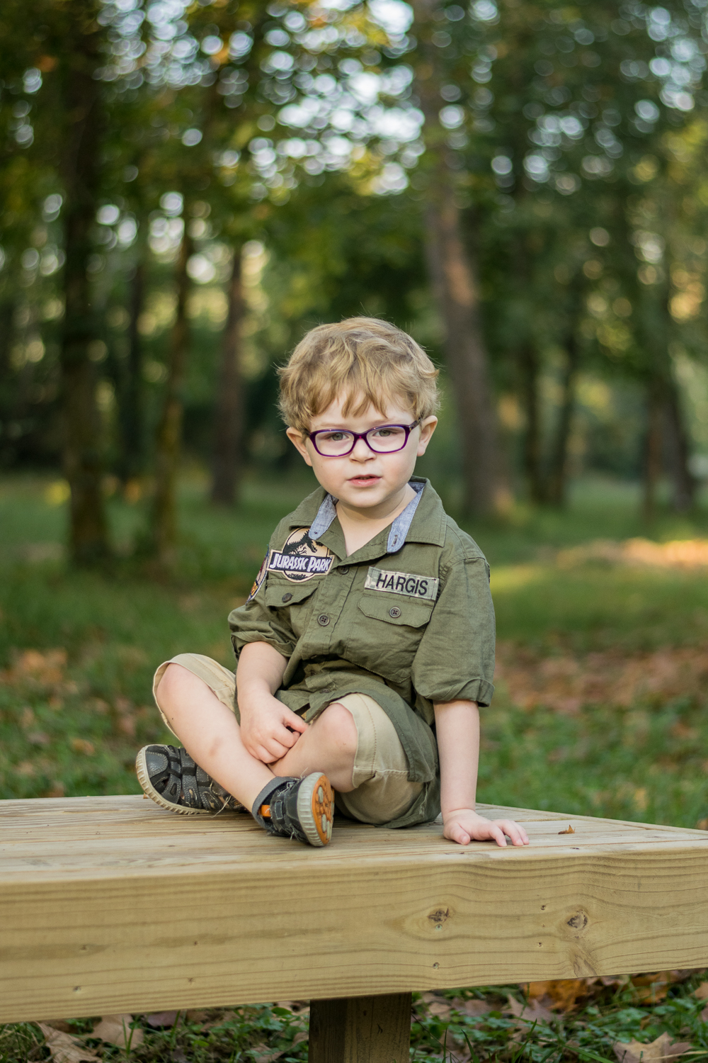 A young boy sitting on a wooden bench at Baker Creek.