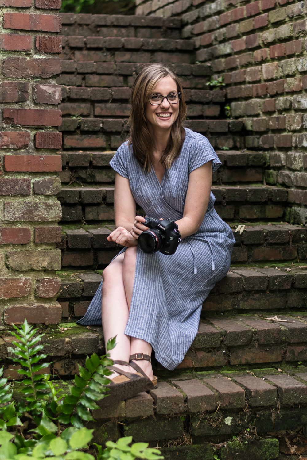 Knoxville photographer Krista Weatherholt sits on brick steps with her camera in hand.