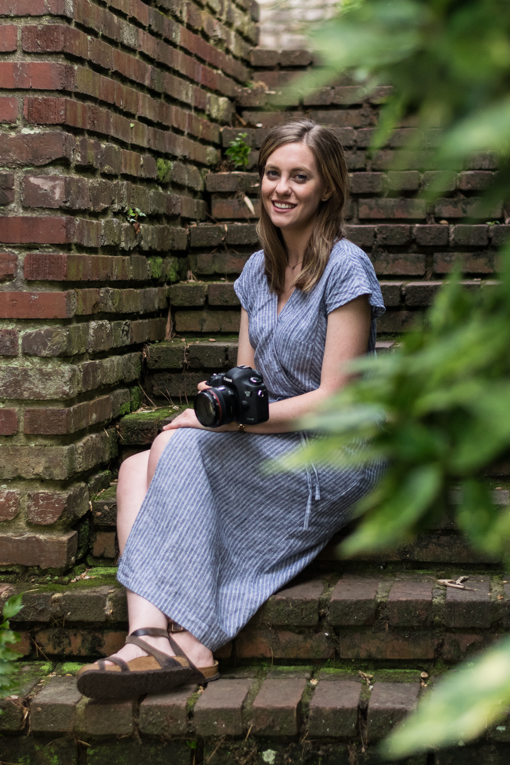 Knoxville photographer Krista Weatherholt sits on brick steps with her camera.