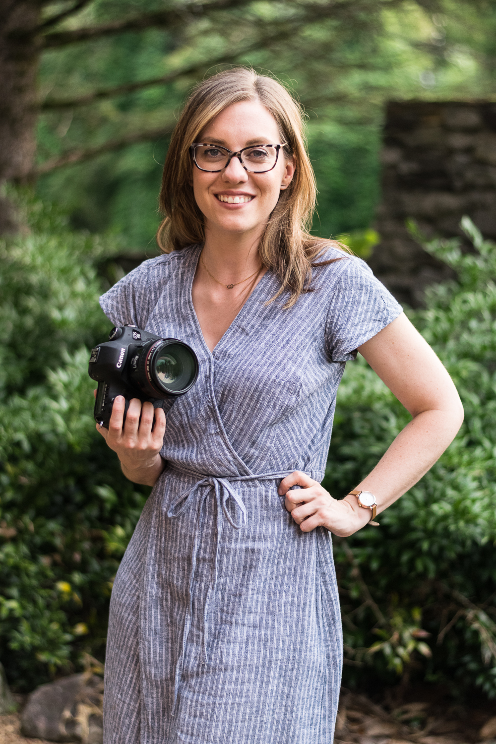 Knoxville photographer Krista Weatherholt holds her camera in a garden.