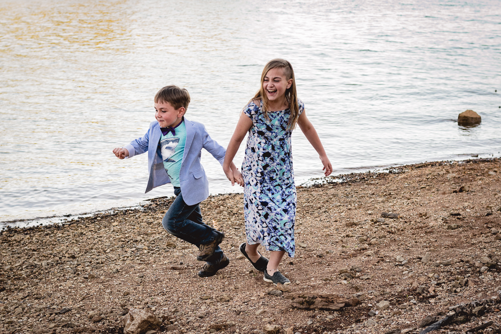Siblings playing by the water at the shoreline of the Tennessee River.