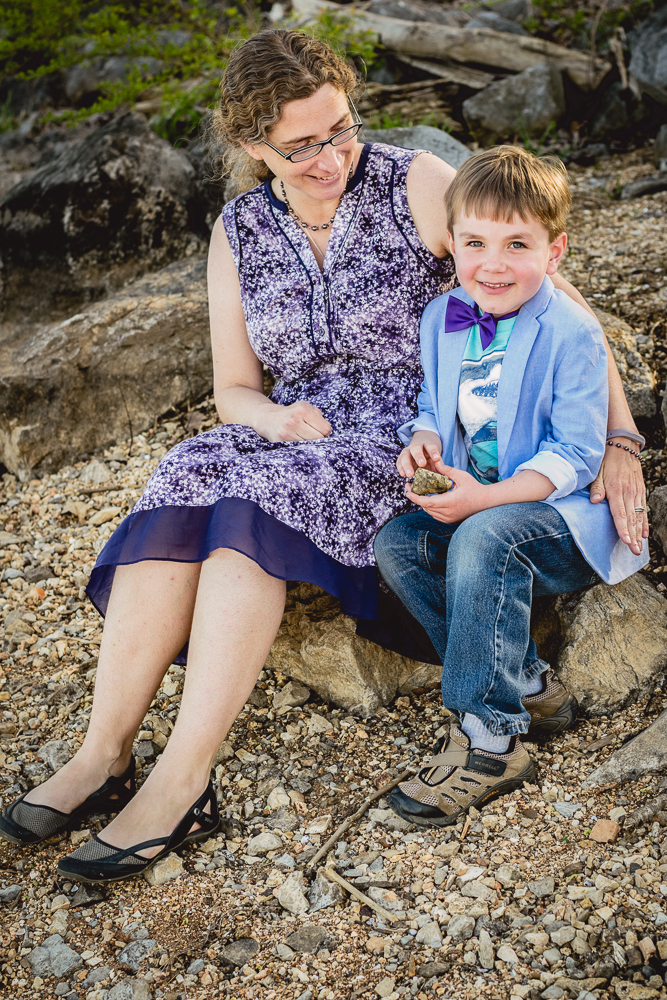 A young boy sits with his mother on the rocks at Admiral Farragut Park.