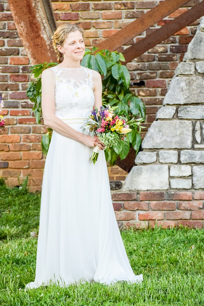 Bride stands with her bouquet at Museum of Appalachia.