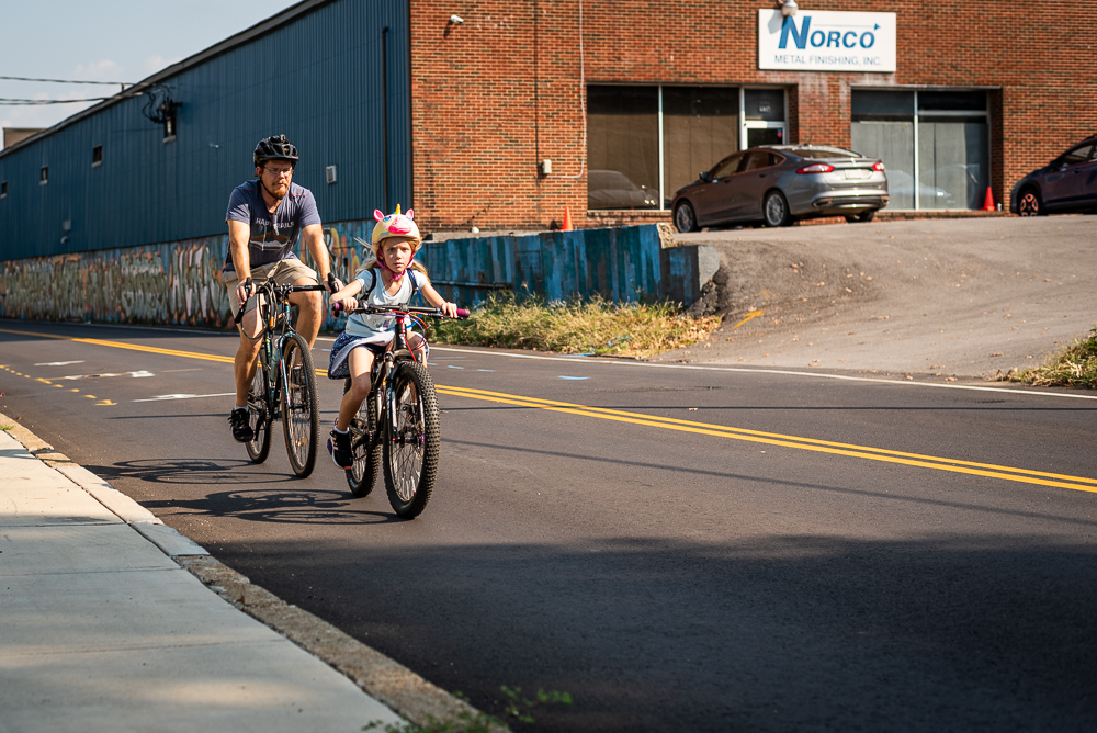 A father and daughter ride bikes along Sevier Avenue at Pedal Jam Knoxville.