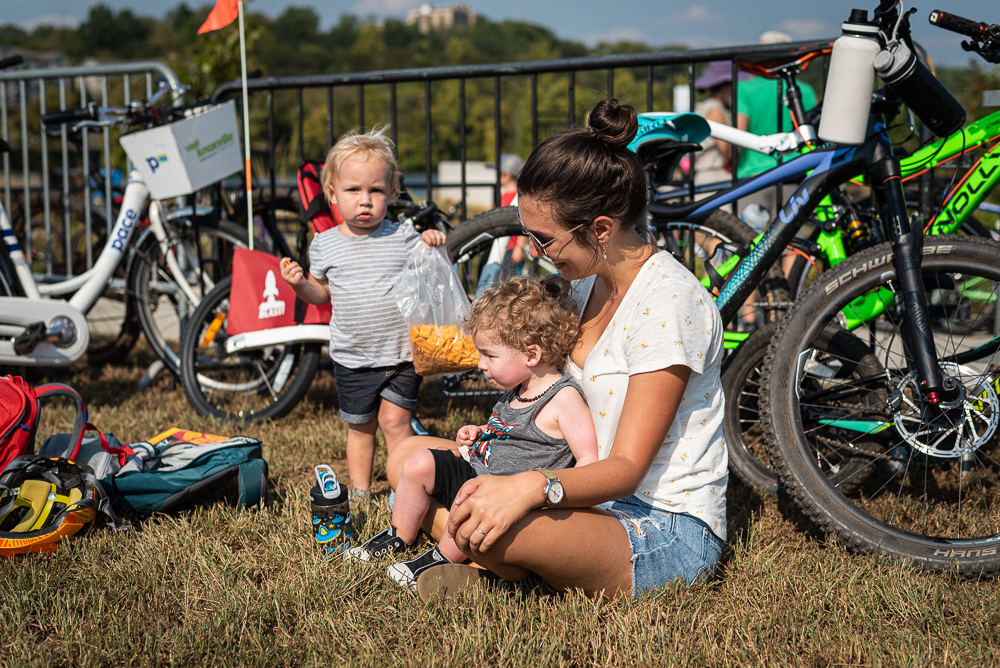 A family sits in the grass among bicycles to have a snack at Pedal Jam Knoxville.