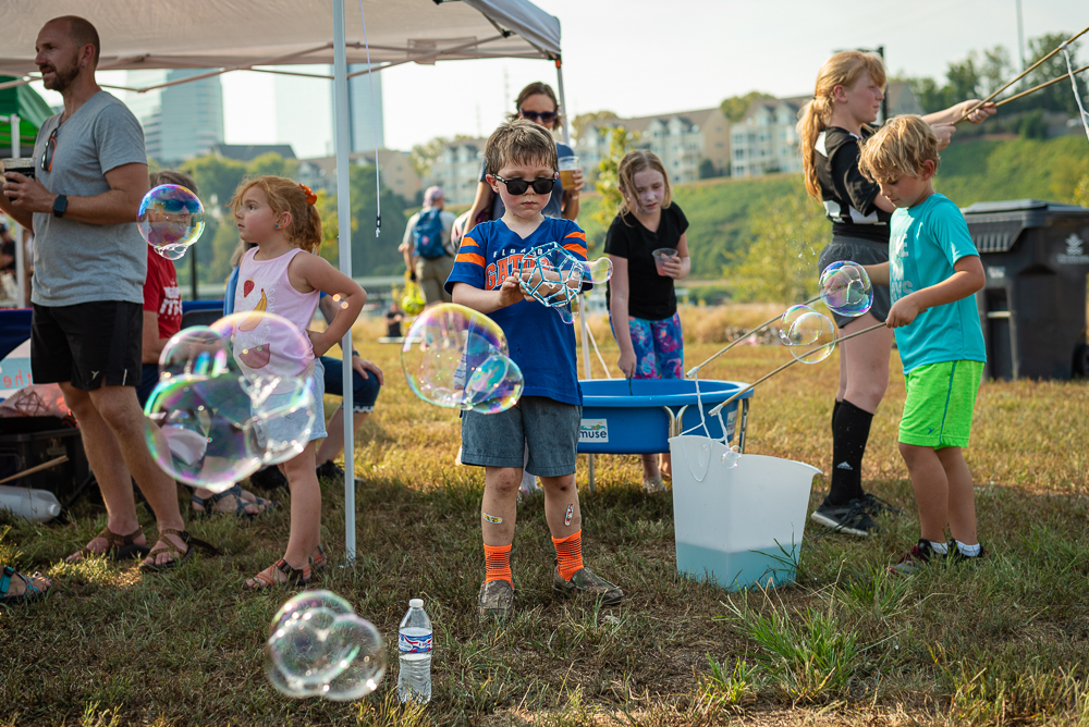 A little boy plays with bubbles at Pedal Jam Fundraiser at Suttree Landing Park.