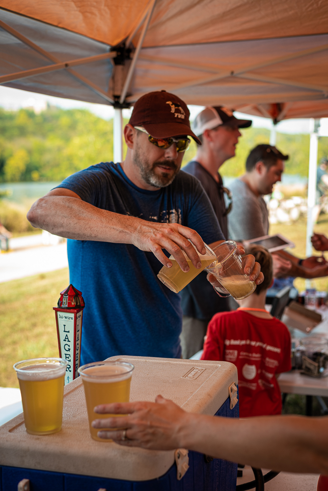 An AMBC volunteer pours beer at Pedal Jam Knoxville Fundraiser.