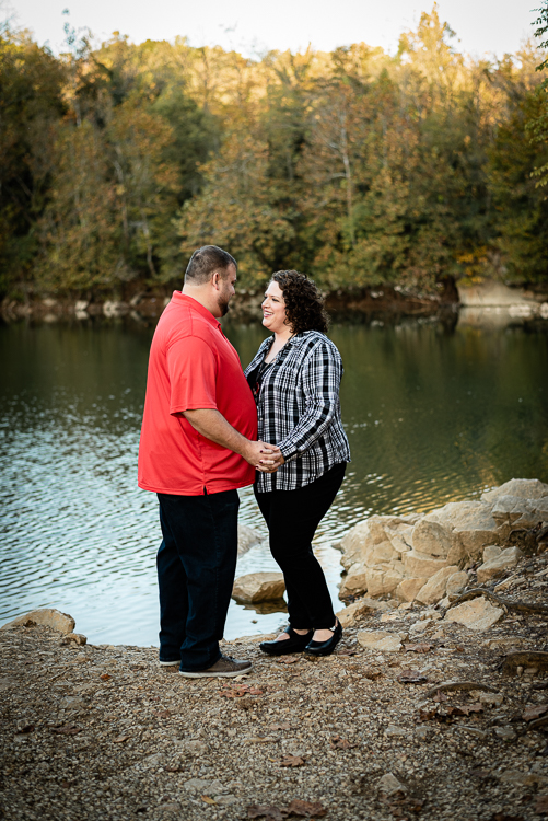 A couple stands at Meads Quarry lake in the fall.