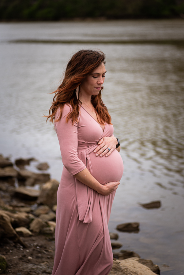 Maternity photos with a woman along the Tennessee River shoreline.