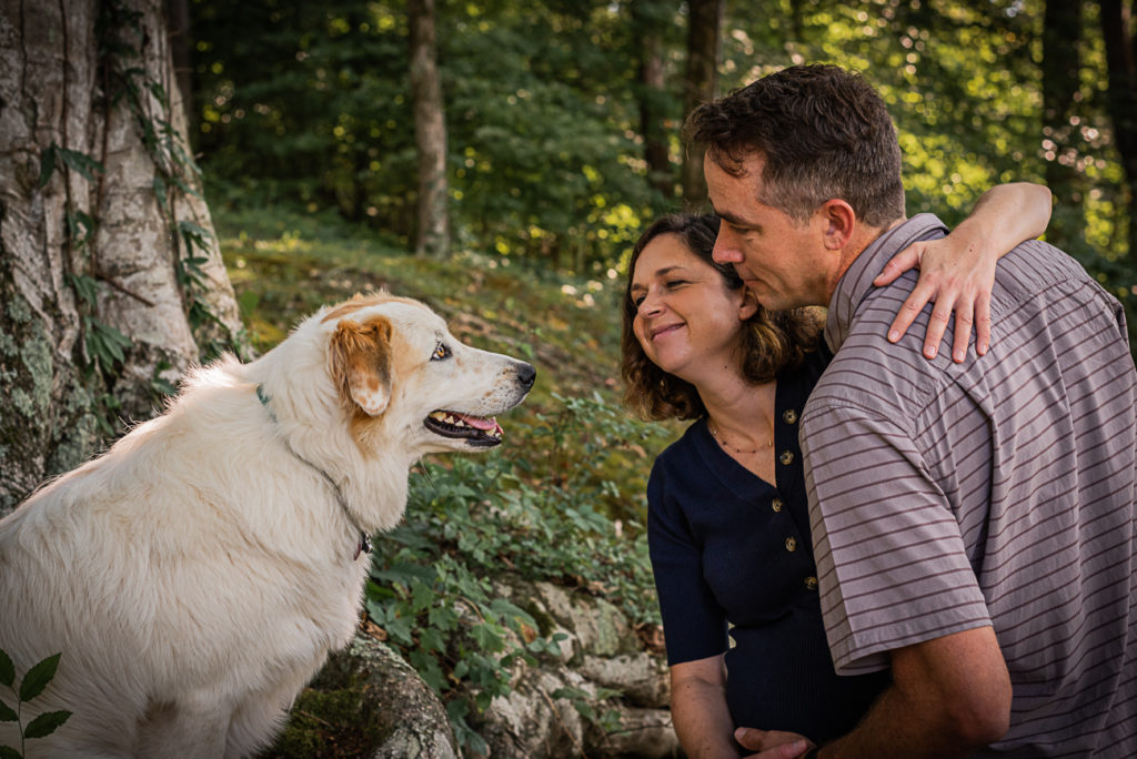 A couple looks at their big, white dog.