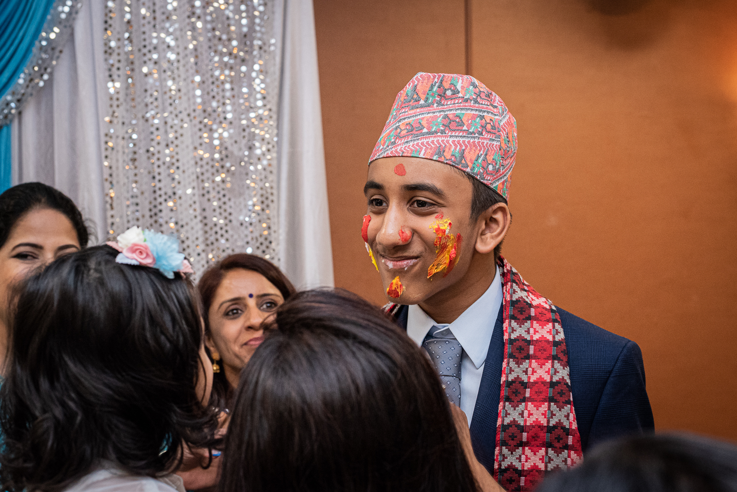 A young man at his Bratabandha ceremony with icing on his face.