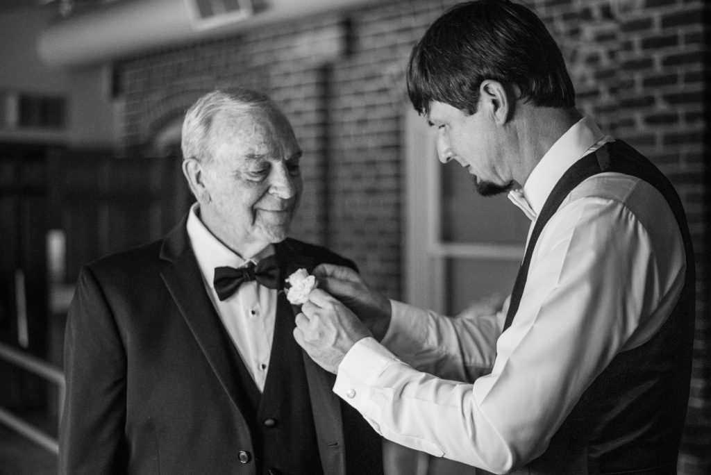 The groom helps his father-in-law get ready at a wedding at the Foundry.