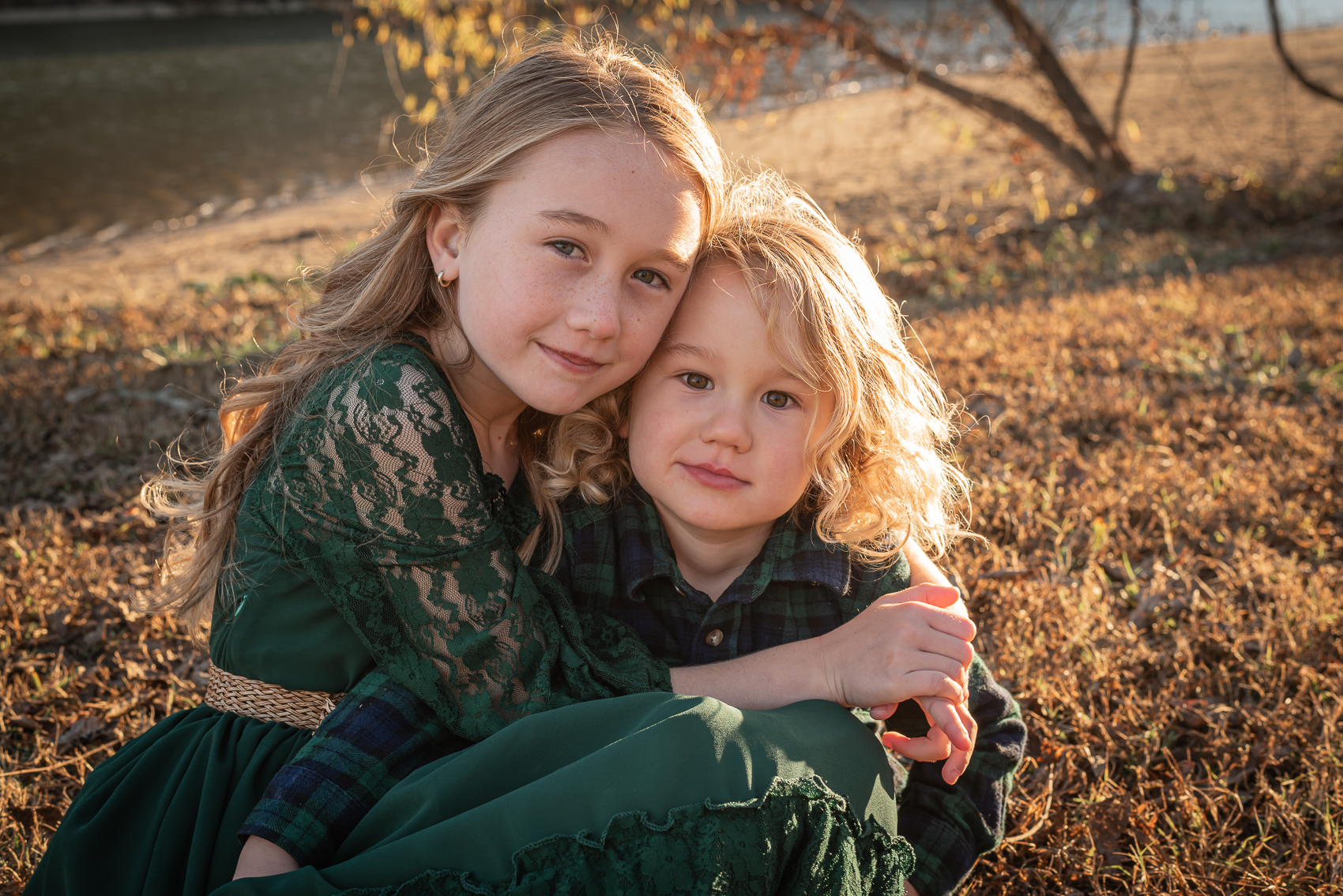 Two children hug in the sunshine by the Tennessee River.