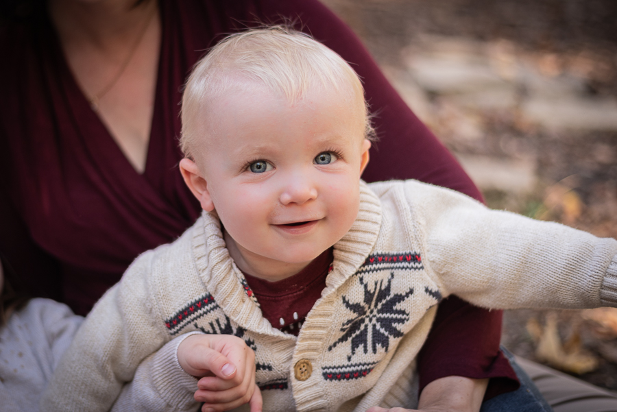 A smiling baby boy with bright blue eyes and blonde hair.