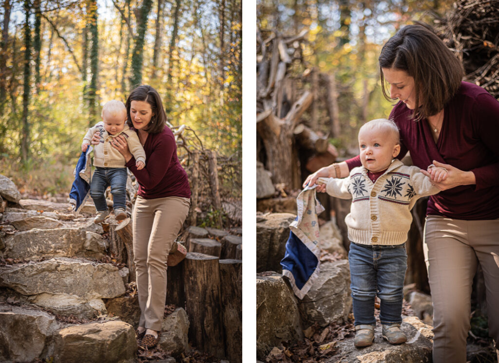 A baby boy plays on stone steps in the forest with his mother.