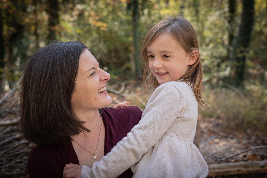 A mother smiling at her daughter in the forest.